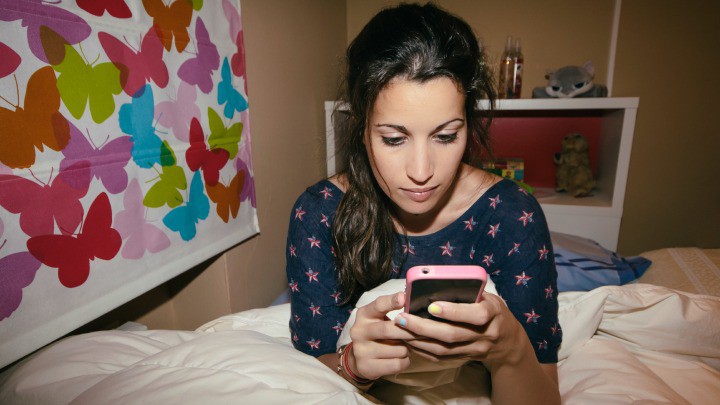 girl in her bedroom texting