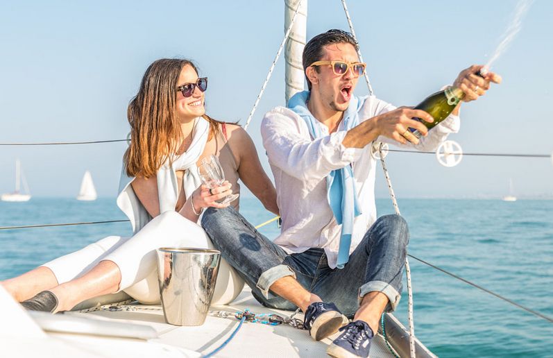 man and woman celebrating on a sailing boat