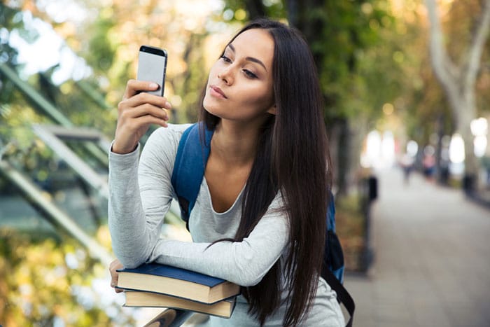 woman outside texting questions